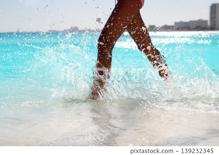 Woman legs walking splashing beach aqua water Woman legs walking splashing beach aqua water 139232345