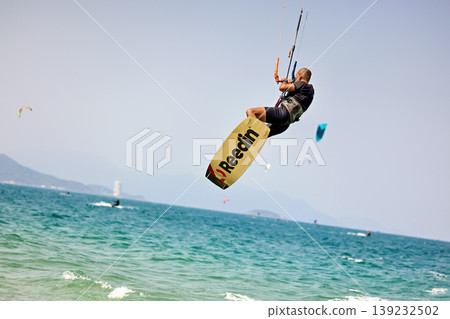 Kitesurfer High Jump Above Sea With City Background Kitesurfer High Jump Above Sea With City Background 139232502