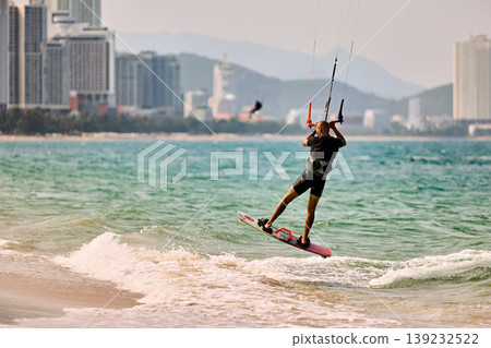 Kitesurfer High Jump Above Sea With City Background Kitesurfer High Jump Above Sea With City Background 139232522