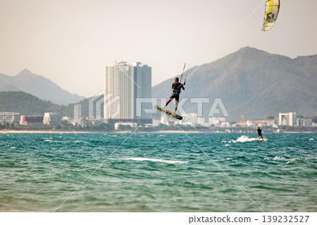 Kitesurfer High Jump Above Sea With City Background Kitesurfer High Jump Above Sea With City Background 139232527