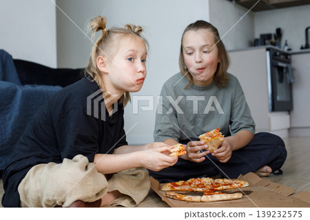 Pretty friends girl and boy eating pizza at home Pretty friends girl and boy eating pizza at home 139232575