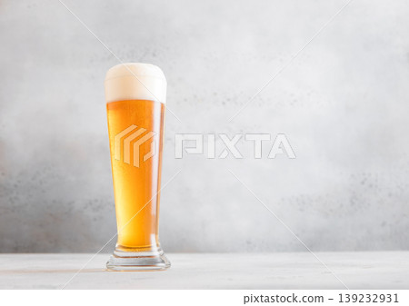 Glass of fresh craft premium lager ale beer on light table background. Glass of fresh craft premium lager ale beer on light table background. 139232931