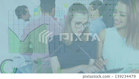 Two women examining tablet in conference room with glass board sticky notes, data overlays Two women examining tablet in conference room with glass board sticky notes, data overlays 139234479