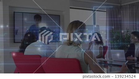 Viewing remote presenter on screen, team sitting around glass table in office with digital overlays Viewing remote presenter on screen, team sitting around glass table in office with digital overlays 139234524