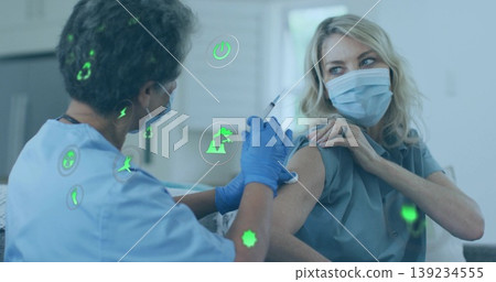 Nurse with mask and gloves administering vaccine to patient in clinic, with green icons Nurse with mask and gloves administering vaccine to patient in clinic, with green icons 139234555