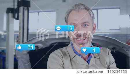 Standing mechanic wearing work coat in auto shop, with open car hood, social icons, copy space 139234563