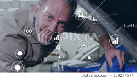 Cleaning adult male mechanic wiping engine bay inside garage, with blue cloth, digital eco icons Cleaning adult male mechanic wiping engine bay inside garage, with blue cloth, digital eco icons 139234574