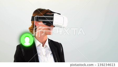 Exploring businesswoman wearing VR headset in studio, with overlays and green user icon Exploring businesswoman wearing VR headset in studio, with overlays and green user icon 139234613