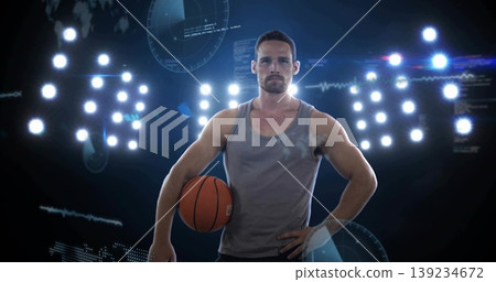 Standing athlete wearing tank top, shorts in studio, holding basketball amid lights, graphics Standing athlete wearing tank top, shorts in studio, holding basketball amid lights, graphics 139234672