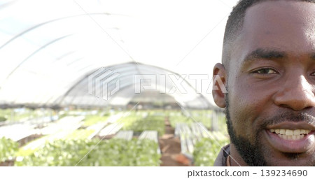 Inspecting bearded farmer tending crops in arched plastic greenhouse, irrigation tubing, copy space Inspecting bearded farmer tending crops in arched plastic greenhouse, irrigation tubing, copy space 139234690