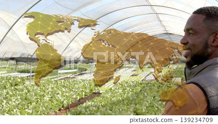 Farmer in puffer vest examining hydroponics in greenhouse, with map overlay, copy space Farmer in puffer vest examining hydroponics in greenhouse, with map overlay, copy space 139234709