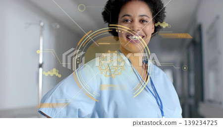 Standing nurse projecting yellow-gold HUD overlay, smiling in hospital corridor, copy space Standing nurse projecting yellow-gold HUD overlay, smiling in hospital corridor, copy space 139234725