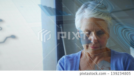 Holding tablet and scanning digital overlays near window, woman in cardigan and blouse, copy space Holding tablet and scanning digital overlays near window, woman in cardigan and blouse, copy space 139234805