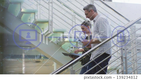 Descending executives in suits using smartphone, tablet on atrium steps with call icons, copy space Descending executives in suits using smartphone, tablet on atrium steps with call icons, copy space 139234812