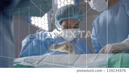 Mid adult surgeon in blue gown making incision in operating room, with scalpel and forceps Mid adult surgeon in blue gown making incision in operating room, with scalpel and forceps 139234876