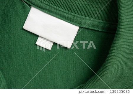 Blank white laundry care clothes label on green shirt fabric texture background Blank white laundry care clothes label on green shirt fabric texture background 139235085