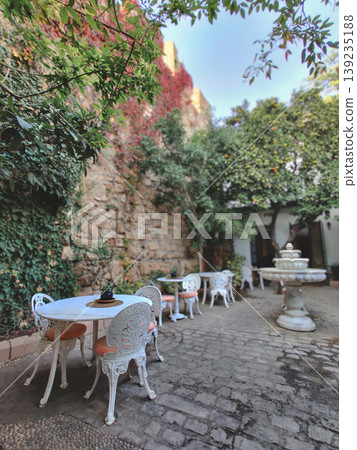 Cozy outdoor cafe terrace with white vintage furniture and stone walls in Turkey Cozy outdoor cafe terrace with white vintage furniture and stone walls in Turkey 139235188