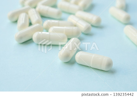 White medicine pills capsule on blue background White medicine pills capsule on blue background 139235442