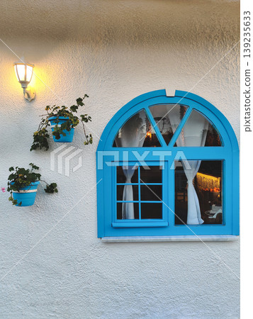 Blue arched window with decorative flower pots in Demre, Turkey 139235633