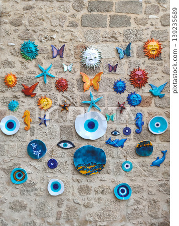 Decorative stone wall with colorful ceramic suns and evil eye nazar ornaments in Turkey Decorative stone wall with colorful ceramic suns and evil eye nazar ornaments in Turkey 139235689