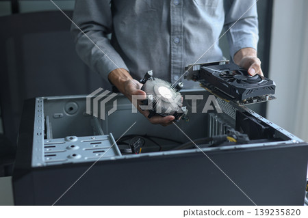 Close-up of electronic technician hands working on computer repair. Close-up of electronic technician hands working on computer repair. 139235820