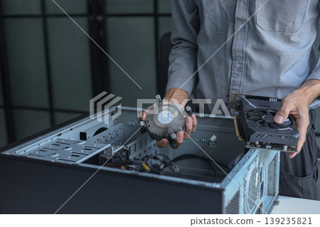 Close-up of electronic technician hands working on computer repair. Close-up of electronic technician hands working on computer repair. 139235821
