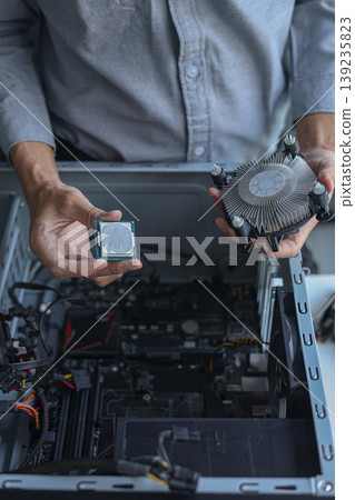 Computer engineer repair and assembling high-performance PC, CPU and cooler at workshop desk. Computer engineer repair and assembling high-performance PC, CPU and cooler at workshop desk. 139235823