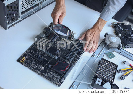 Closeup of electronic technician hands working on computer hardware and mainboard repair. Closeup of electronic technician hands working on computer hardware and mainboard repair. 139235825