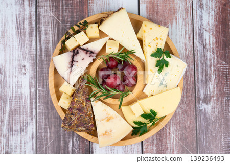 Artisanal cheese platter with grapes and fresh herbs Artisanal cheese platter with grapes and fresh herbs 139236493
