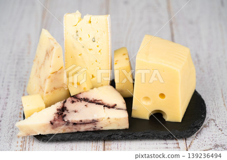 Artisanal cheese assortment on a black slate and wooden background Artisanal cheese assortment on a black slate and wooden background 139236494