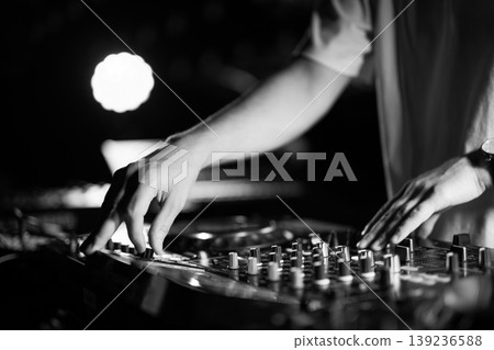 Black and white close-up of DJ hands mixing music on professional equipment Black and white close-up of DJ hands mixing music on professional equipment 139236588