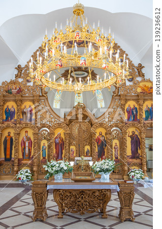 Grand church interior with golden chandelier and carved iconostasis 139236612