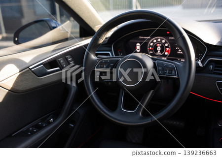 Interior view of a modern luxury car featuring the steering wheel and digital dashboard 139236663
