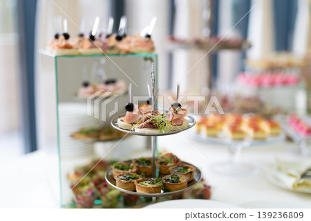 Gourmet appetizers on tiered serving stands at a catered event 139236809