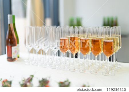 Row of champagne glasses filled with sparkling wine at a catered event 139236810