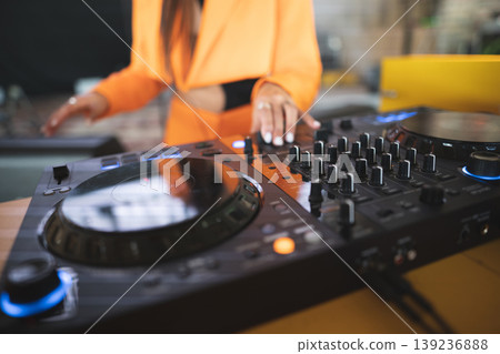 a DJ plays music on a controller at a party a DJ plays music on a controller at a party 139236888