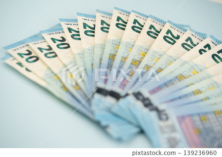 many 20 euro bills on a blue background many 20 euro bills on a blue background 139236960