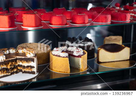 Variety of gourmet cakes and pastries in a bakery display case 139236967