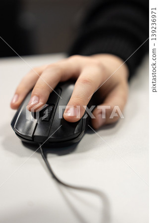 Close-up of a hand using a black computer mouse Close-up of a hand using a black computer mouse 139236971