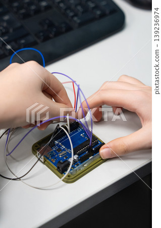 Student working with Arduino microcontroller and breadboard Student working with Arduino microcontroller and breadboard 139236974