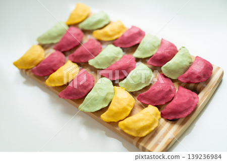 Colorful handmade dumplings arranged on a wooden board Colorful handmade dumplings arranged on a wooden board 139236984
