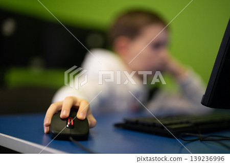 Young boy using a computer mouse in a digital classroom Young boy using a computer mouse in a digital classroom 139236996