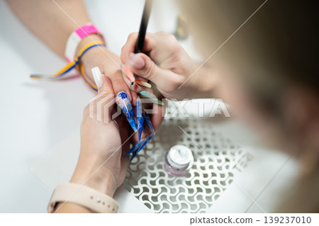 Manicurist applying top coat to textured nail art Manicurist applying top coat to textured nail art 139237010
