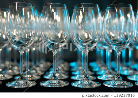 Rows of empty wine glasses on a dark background with blue lighting Rows of empty wine glasses on a dark background with blue lighting 139237016