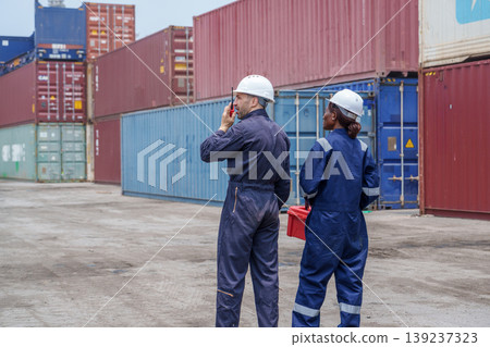 Diverse Mid-adult Caucasian Male and Black Female Logistics Workers Using Radio at a Cargo Shipping Terminal 139237323