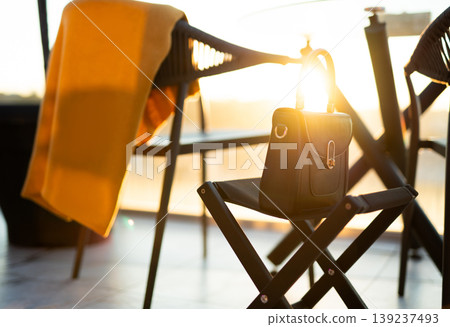 Elegant handbag on a folding stool in golden hour light 139237493