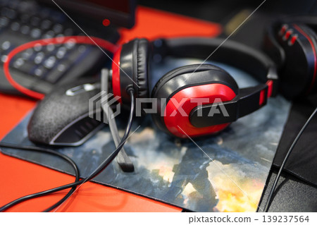 Red and black gaming headset on a mousepad Red and black gaming headset on a mousepad 139237564