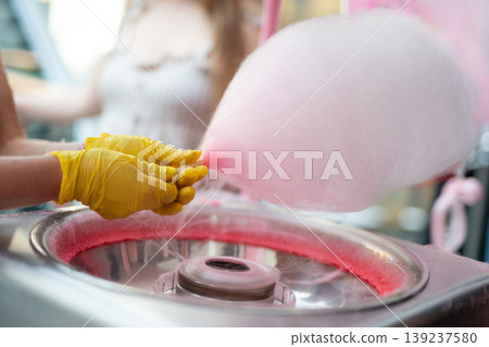 Making pink cotton candy at an outdoor festival Making pink cotton candy at an outdoor festival 139237580