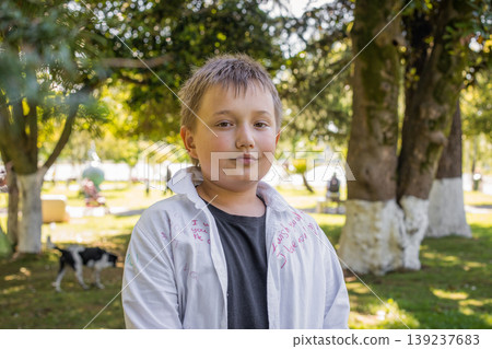 Happy young boy portrait. Child playing in park outdoors Happy young boy portrait. Child playing in park outdoors 139237683
