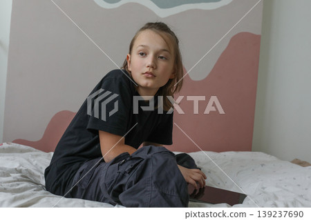 Happy child with gadget pc tablet sitting at home Happy child with gadget pc tablet sitting at home 139237690